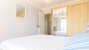 Un dormitorio con una cama grande, un espejo y un armario.