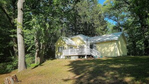A two-story cabin with a porch, surrounded by trees. - The "Frolic" (Pullman)