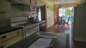 A kitchen with a gas stove, microwave, and a dining area with a table and chairs. - The "Frolic" (Pullman)