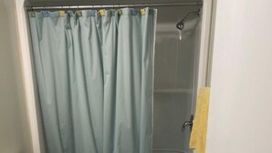A bathroom with a toilet, a bathtub, and a shower. - Cabin on the beach. (Miramichi)