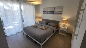 A modern bedroom with a bed, two bedside tables, a ceiling light, and a window with curtains. - Prestige view 411 by Avecoeur (Èze)