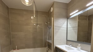 A modern bathroom with a bathtub, two sinks, a shower, and a large mirror. - Prestige view 411 by Avecoeur (Èze)