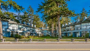 A modern hotel with multiple-story buildings, large windows, and a well-maintained lawn.