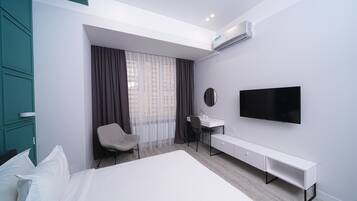 Une chambre d’hôtel moderne équipée d’un lit, d’un bureau, d’une chaise, d’une télévision et d’un appareil de climatisation.