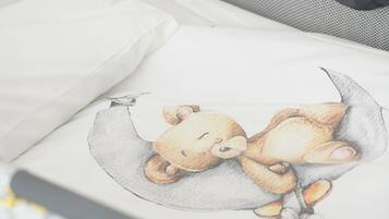 A crib with a white mattress and a blanket with a bear design.
