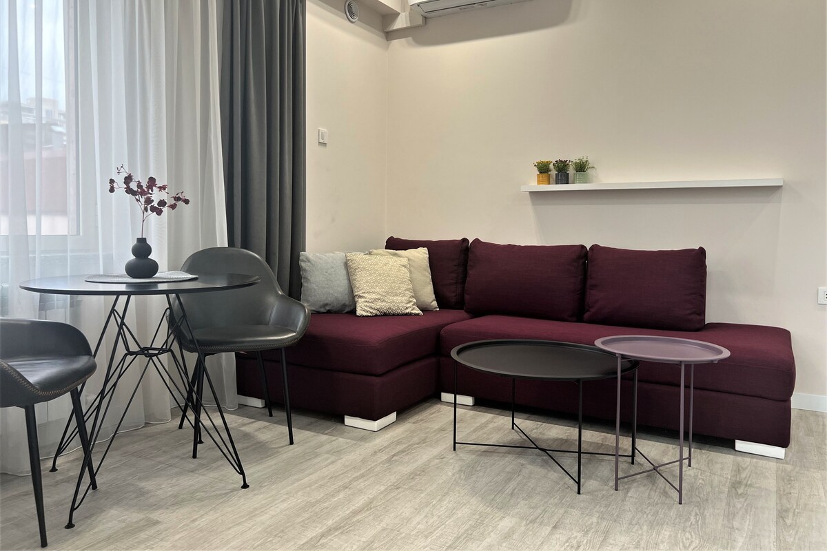 A modern living room with a sectional sofa, a round coffee table, and a small side table.