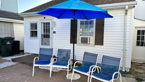 A patio with two blue chairs and a blue umbrella. - 1BR Cottage Close to Beach! (Wildwood)