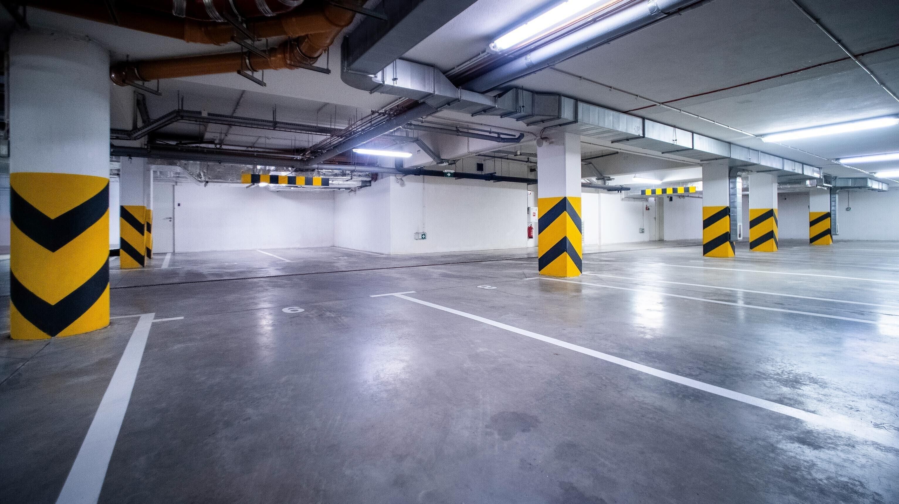 A multi-level parking garage with concrete pillars and overhead lighting.
