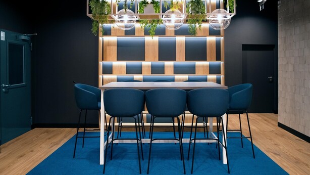 A modern dining area with a booth-style table, blue chairs, and a blue carpet. - B&B HOTEL Kielce Centrum (Kielce)