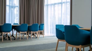A conference room with a table and chairs, large windows with curtains, and a carpeted floor. - B&B HOTEL Kielce Centrum (Kielce)