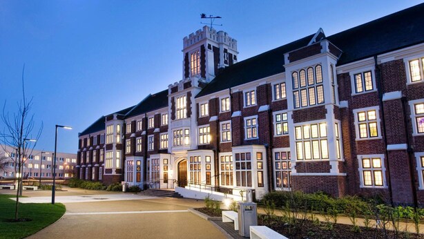 A large, multi-story building with a prominent tower and arched windows, likely a hotel or institutional building.