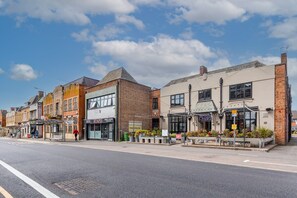 A street with various shops, including a restaurant and a pizzeria.
