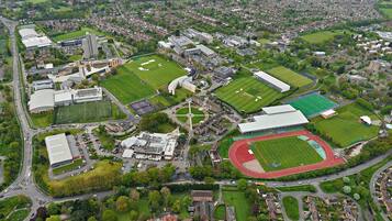 An aerial view of a campus with multiple sports fields, buildings, and roads.