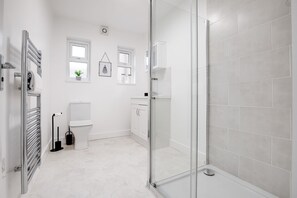 Une salle de bain moderne avec une douche à parois de verre, des toilettes et un lavabo.