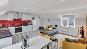 A modern apartment with a kitchen, dining area, and living room.