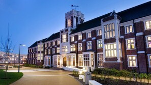 Un grand bâtiment à plusieurs étages, doté d’une tour imposante et de fenêtres en arc de cercle, qui ressemble probablement à un hôtel ou à un bâtiment institutionnel.