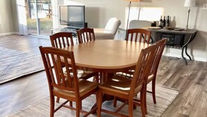 A dining area with a wooden table and chairs, a ceiling fan, and a view of the outdoors. - Lakefront views at our Long Island Lookout! (Belle Center)