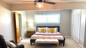 A bedroom with a bed, a nightstand, a lamp, a ceiling fan, a chair, and a closet. - Lakefront views at our Long Island Lookout! (Belle Center)