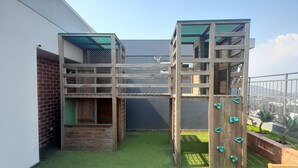 A rooftop play area with climbing structures and a small seating area.