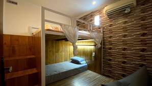 Una habitación con literas, un escritorio pequeño y una silla.