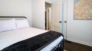 Een slaapkamer met een bed, een deur en een muur met een bloemschildering.
