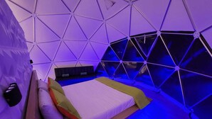 Ein modernes Zimmer im geometrischen Stil mit einem Bett, Kissen und einer Bank.
