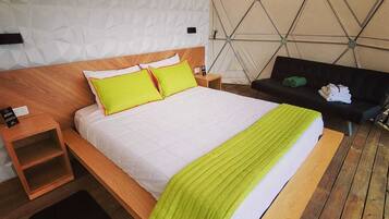 Un dormitorio moderno con una cama de madera, ropa de cama blanca y un diseño geométrico en la pared.