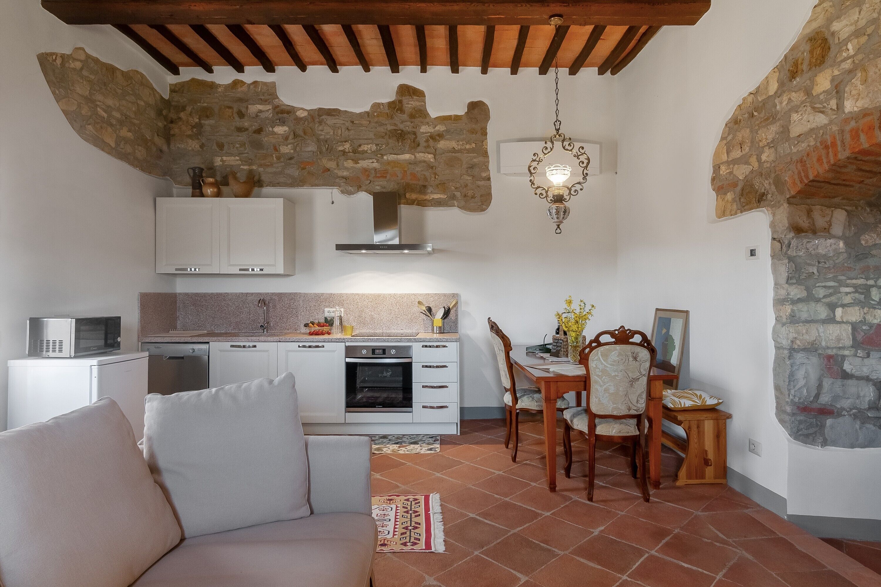 A compact living space with a kitchenette, a dining area, and a sofa.