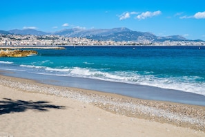 A beach with a clear view of the sea and distant mountains.