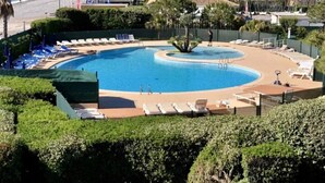 Une piscine avec des chaises longues et vue sur la mer.