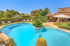 A swimming pool with lounge chairs and a patio area. - Villa Bon Reco by Villa Plus (Pollença)