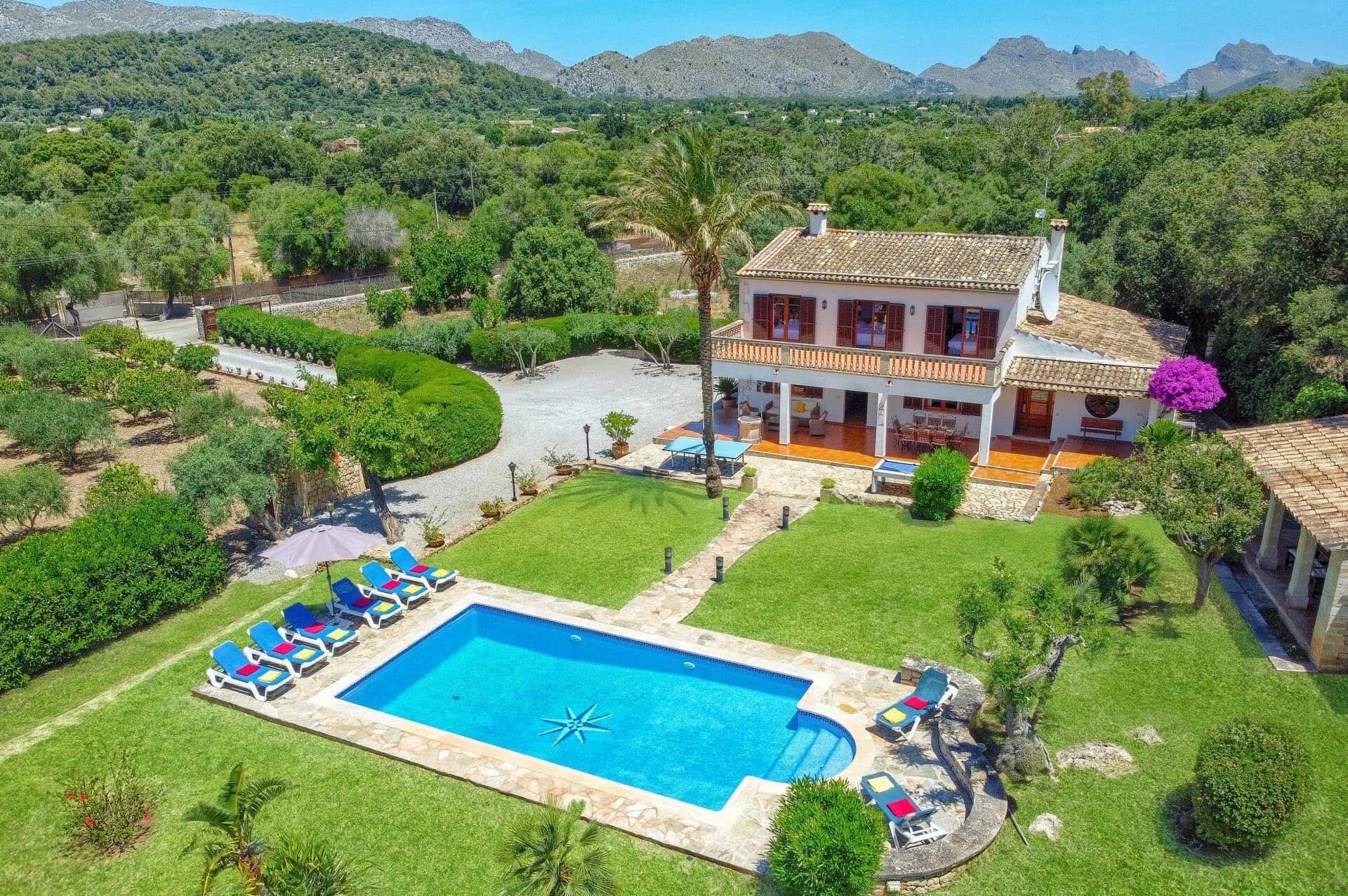 A two-story house with a swimming pool and outdoor seating.