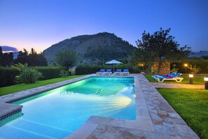 Une piscine avec des chaises longues et une vue sur les montagnes en arrière-plan.