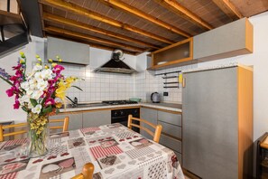 A kitchen with a tiled backsplash, a stove, and a refrigerator.