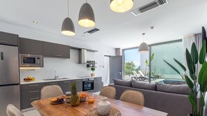 Una cucina moderna con zona pranzo, un'ampia finestra e vista sulla piscina.