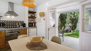 Eine moderne Küche mit Essbereich, einem großen Fenster und Blick auf Grünflächen.