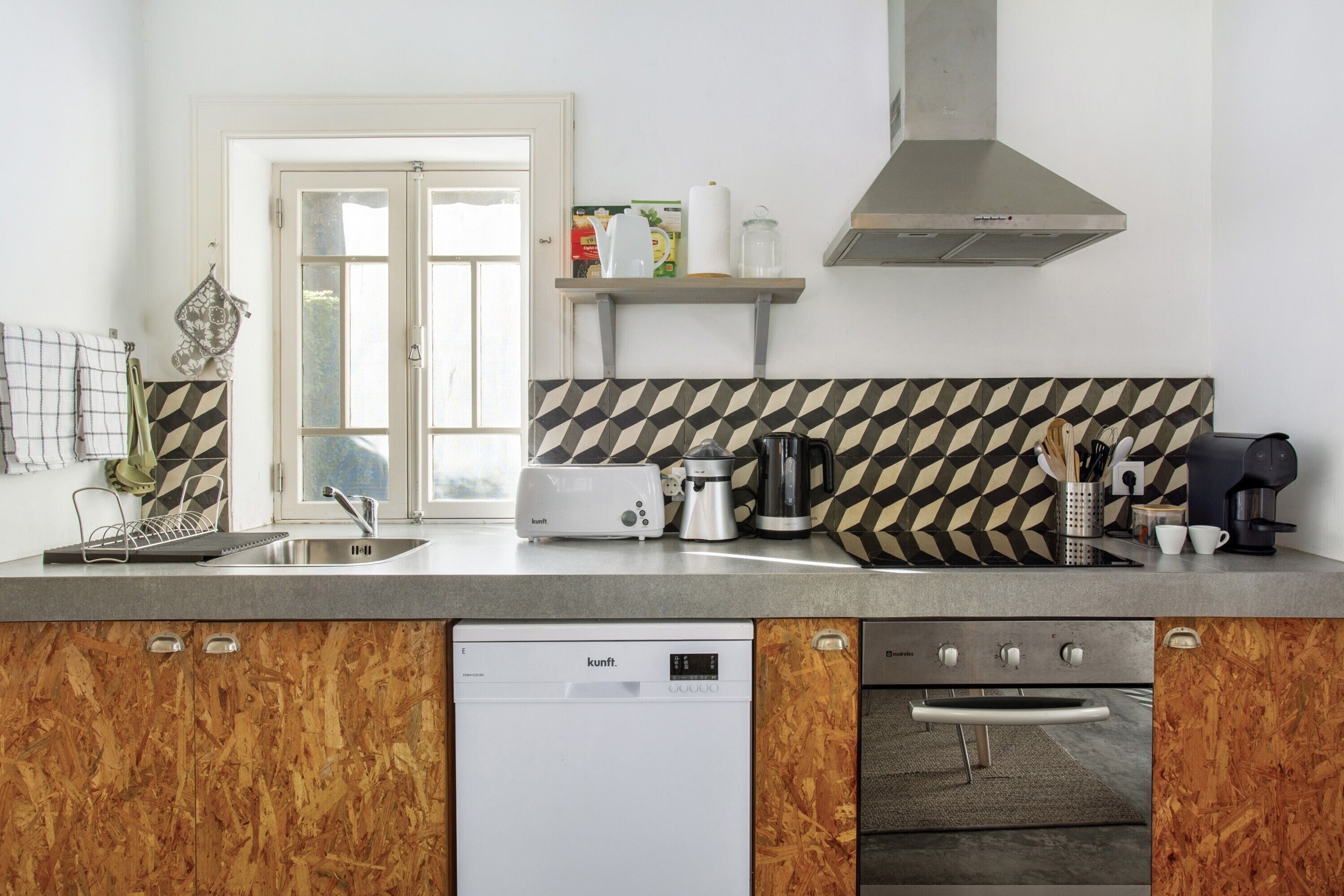 Una cocina equipada con lavavajillas, horno, tostadora, hervidor y cafetera.