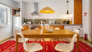 Una cocina moderna con una mesa de comedor, sillas, microondas, estufa y lavadora.