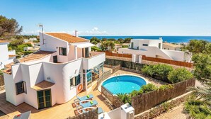 A modern villa with a swimming pool, white walls, and a view of the sea. - Villa Bini Mestral by Villa Plus (Binibeca)
