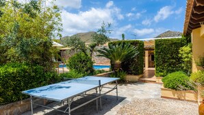 A ping pong table in a courtyard with a pool and mountains in the background. - Villa 'Can Magraner' with Mountain View, Wi-Fi and Air Conditioning (Port de Pollensa)