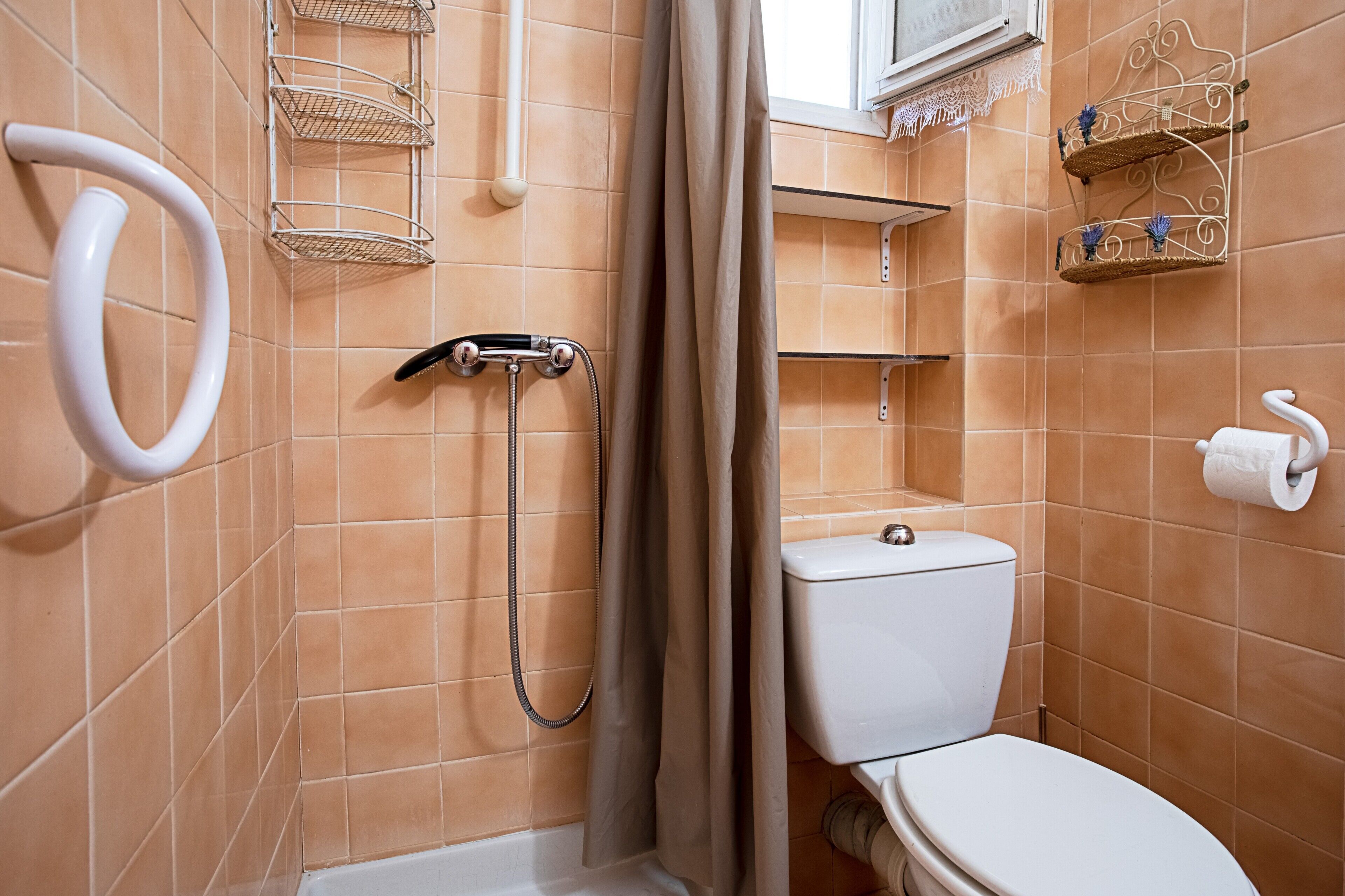 Un bagno con doccia, servizi igienici e porta asciugamani.