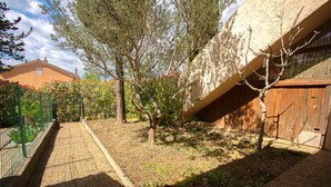 A courtyard with a paved walkway, a tree, and a building with a sloped roof. - "Les Tulipes" Apartment with Private Terrace, Garden, and Wi-Fi (Carqueiranne)