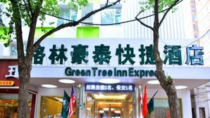 Entrada de un hotel con un letrero que indica Green Tree Inn Express.