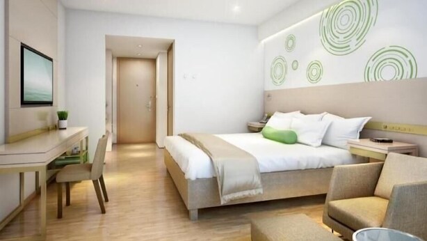Una habitación de hotel moderna con cama, escritorio, silla y una mesita.