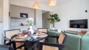 Une cuisine moderne équipée d’un four à micro-ondes, d’une table à manger dressée avec des assiettes, des tasses et un vase de fleurs.