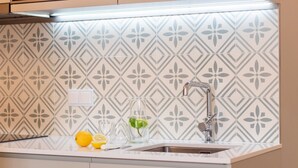 A kitchen with a modern faucet and a patterned backsplash. - Mouzinho 215 - Apartment 303 by LovelyStay (Porto)