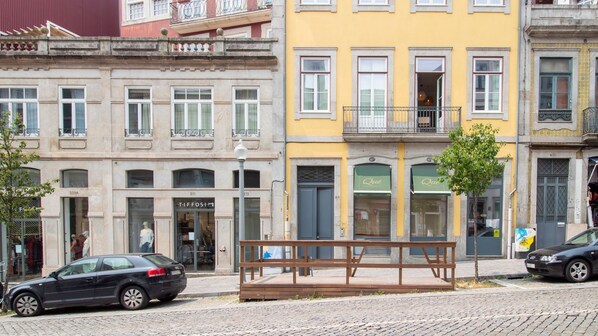 A street view with a row of buildings, including a shop with a visible sign.