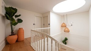 Portaat, joissa on valkoiset kaiteet, ruukkuistutettu kasvi ja kattovalaisin.