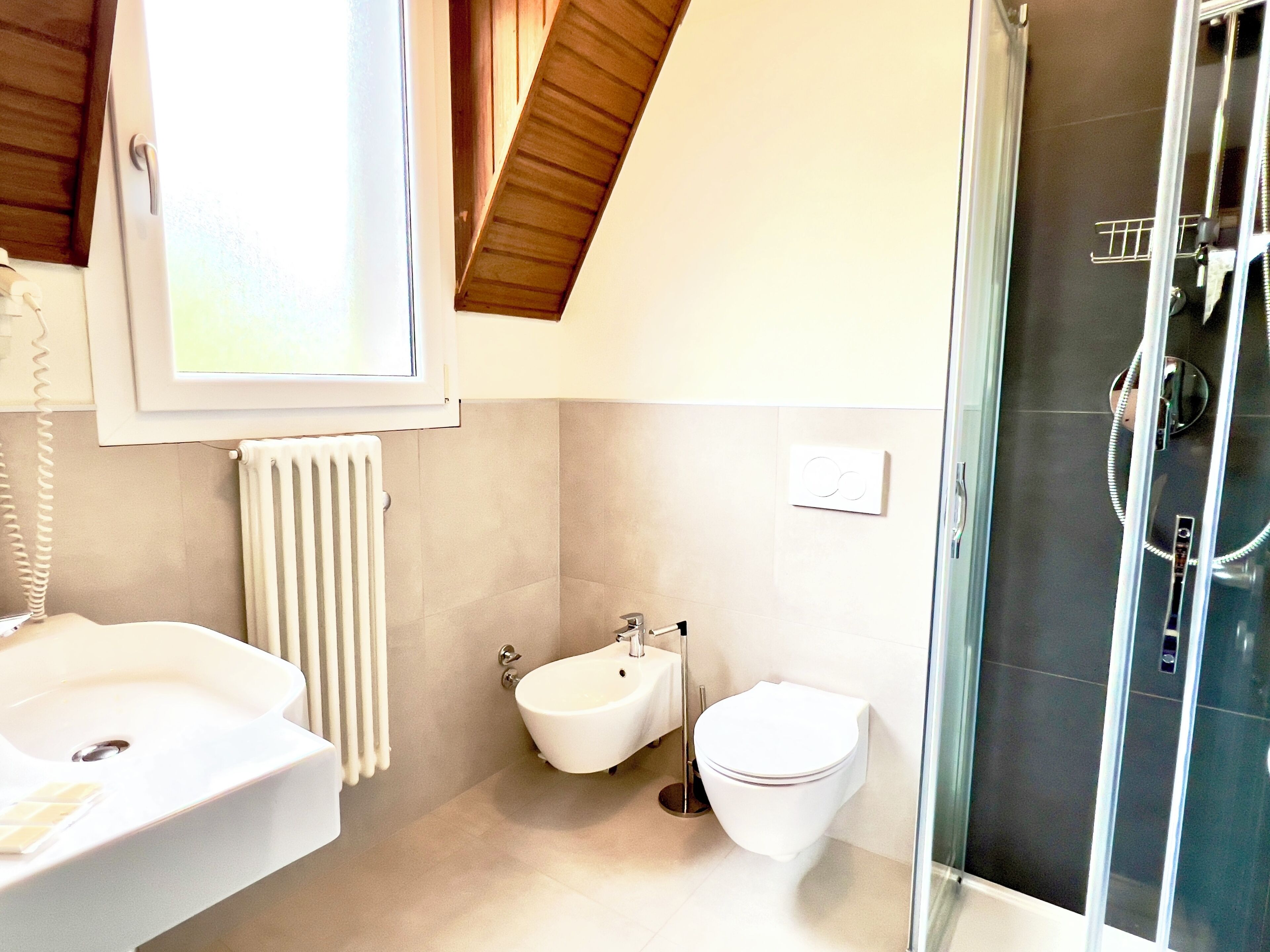 A modern bathroom with a bathtub, a bidet, and a toilet.