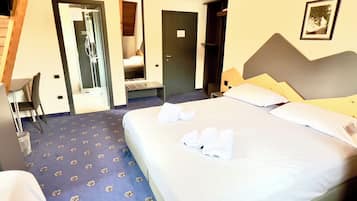 A hotel room with a bed, a desk, and a chair. There is a door leading to a bathroom and a closet.